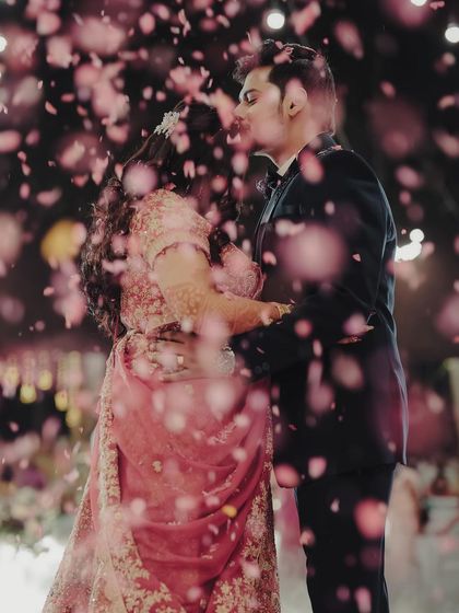 A romantic moment between Bhumi and Avi, surrounded by a shower of pink petals during their reception. We love planning these special touches that make for beautiful memories and photos.