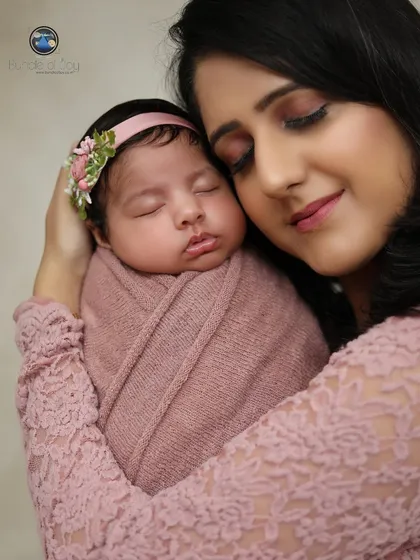 The peacefulness of a mother holding her sleeping child close. The baby is comfortably swaddled, and the mother's gentle expression says it all.
