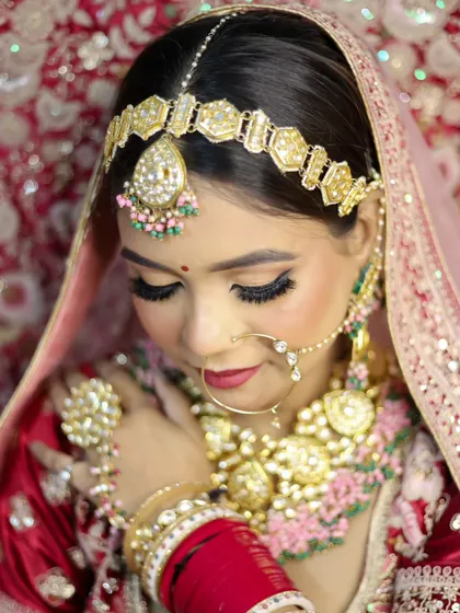 A detailed shot of the bridal makeup, focusing on the soft-glam eyes and perfectly blended skin, complemented by heavy kundan and pearl jewelry.