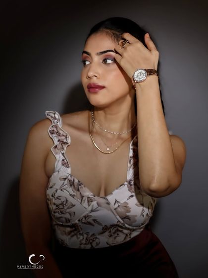 A close-up portrait focusing on beauty and detail. The lighting accentuates her features and the delicate jewelry, creating a look of timeless sophistication.