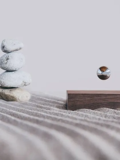 The Buda Ball, set in a tranquil zen garden, demonstrates its purpose as a tool for mindfulness. The chrome sphere levitates and spins, creating a hypnotic effect designed to calm the mind and encourage presence.