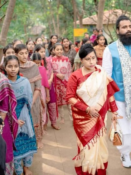 Leading the way with grace and purpose. Mahayogi Madhucarji and Maa Aditiji walk with students at a spiritual event, demonstrating that the path of mindfulness is a journey we take together as a community.