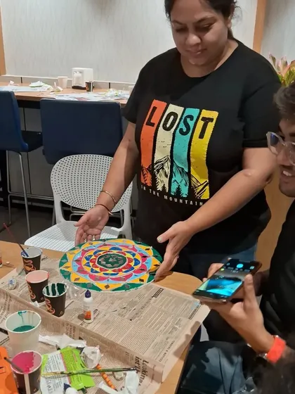 An instructor guiding a student during a Lippan art workshop. We provide personalized attention to ensure everyone learns the technique and leaves with a piece they are proud of.