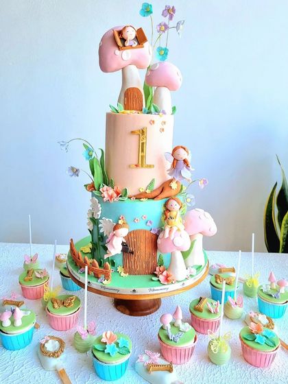 A full view of the enchanted garden cake with matching cupcakes and treats.