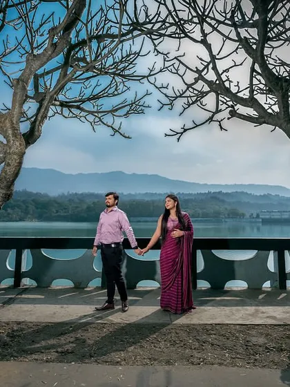 A classic walking shot, framed by two beautiful trees. The mountains and water in the background provide a stunning, panoramic view.