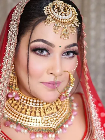 A close-up of the bride, showing the detail on the gold-plated choker and the large, intricate nath.