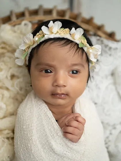 A calm and curious awake shot. The baby is swaddled but her eyes are open, taking in the world around her.