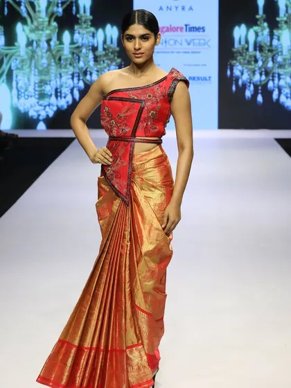 I enjoy reinterpreting traditional fabrics, like this red tishu Kanchi saree. By pairing it with a modern, one-shoulder embroidered crop blouse, I've created a unique fusion look that I showcased at Bangalore Times Fashion Week.