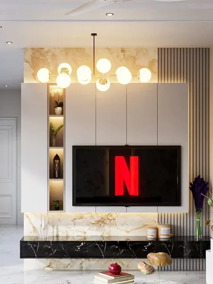 A 3D render of a living room where the TV unit is the star. It features a black marble console, a white paneled wall with integrated display niches, and a statement chandelier that adds a touch of glamour.
