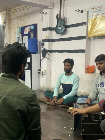A vocal class practices with a harmonium, learning the nuances of Indian classical music. The small group setting allows for personalized feedback.