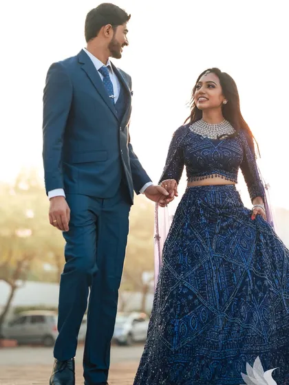 A walking shot of the couple, hand in hand. Dr. Akshara's reception look is elegant and modern, perfect for these stylish portraits.