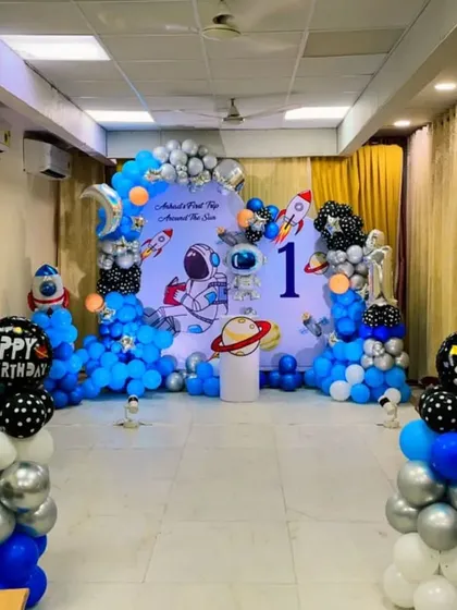 A full view of a space-themed first birthday party setup in a large room.