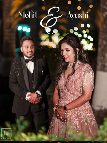 A classic portrait of Mohit and Ayushi from their reception. The soft bokeh of the lights creates a magical, romantic atmosphere, perfect for capturing evening celebration photos.