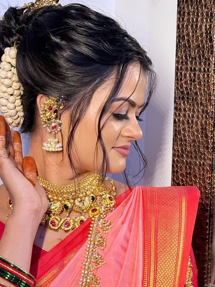 A detailed shot focusing on the side profile, highlighting the intricate jewelry, the flawless skin finish, and the elegant hair bun.