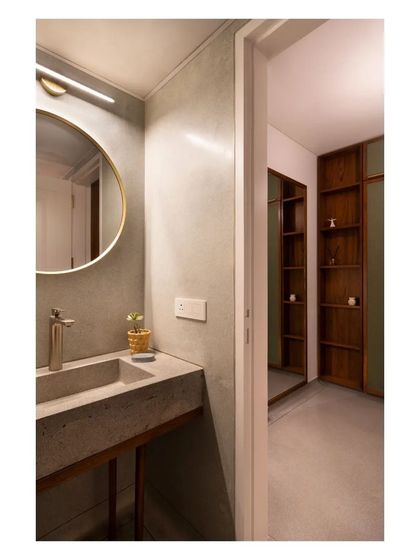 A view from the bathroom into the walk-in closet, showing the continuity of the terrazzo floor and the contrast with the dark wood shelving.