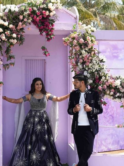 Chasing thrills at the carnival. The couple poses at a cute, house-shaped photo booth adorned with beautiful flowers.