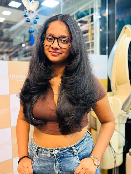 Our client looking confident and stylish with her new layered haircut. The layers are cut to perfectly complement her features.