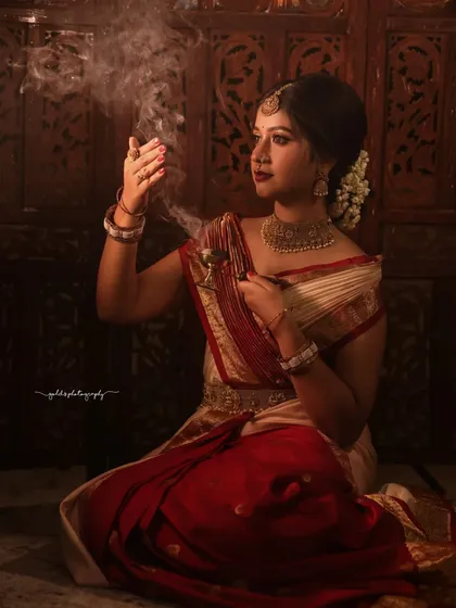 A dramatic portrait using smoke to create a mystical effect. The bride holds a traditional incense burner, adding to the spiritual and artistic mood of the shot.