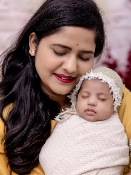 A close-up of a mother holding her peacefully sleeping newborn. The love and serenity in this moment are beautifully captured, highlighting the deep connection between them.