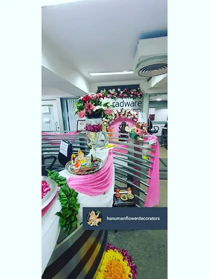 A festive pooja corner set up on an office desk, complete with a small floral arch and fabric draping. We can create these small, personalized sacred spaces within any corporate environment.