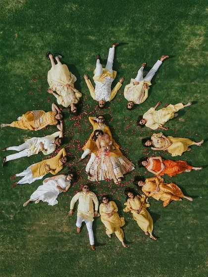 From above, the Haldi ceremony transforms into a beautiful, living mandala of joy. This aerial perspective, captured with a drone, shows the couple at the center of their universe, encircled by the love and vibrant energy of their closest family and friends.