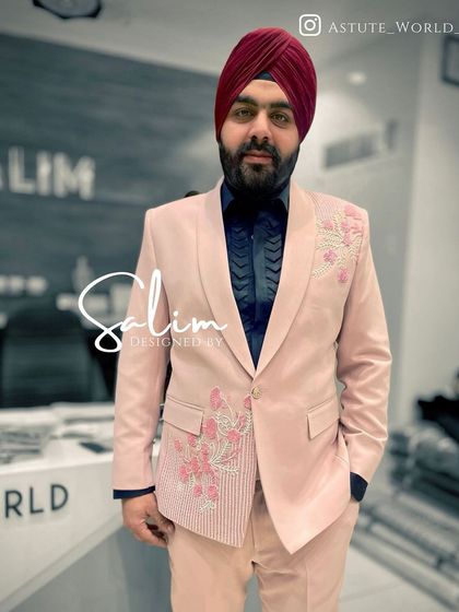 A client in a pink suit with subtle floral embroidery. The tone-on-tone embroidery adds a touch of custom detail to a colorful and modern suit.