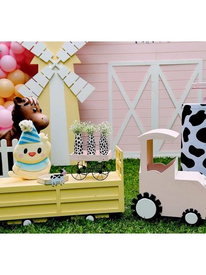 A cute chick-in-a-hat prop sits on a yellow farm cart, adding a touch of whimsy to our barnyard theme.