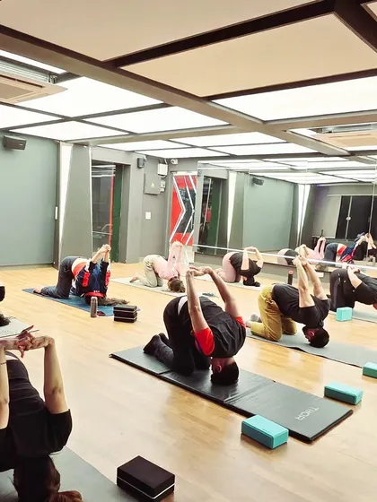 Students in Shashankasana (Rabbit Pose). This pose lengthens the spine, releases pressure on the spinal discs, and strengthens the back muscles.