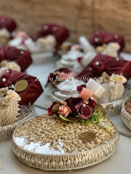 Here are some of my elegant dry fruit platters, designed as wedding return favours. The silver-plated trays are filled with high-quality nuts and decorated with small floral touches, offering a classic and healthy thank you gift for guests.