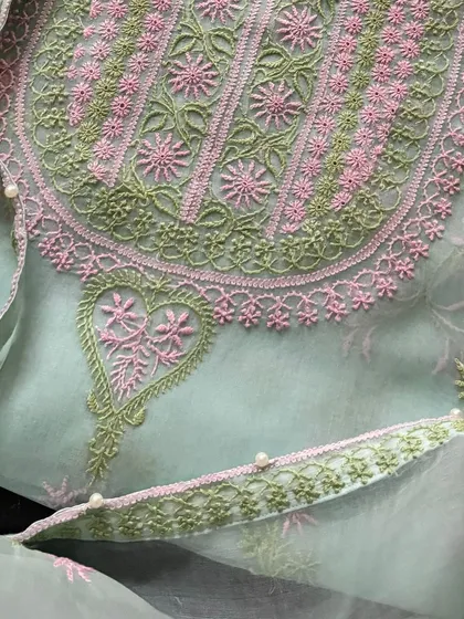 A macro shot of the neckline, showing the precision of the threadwork.