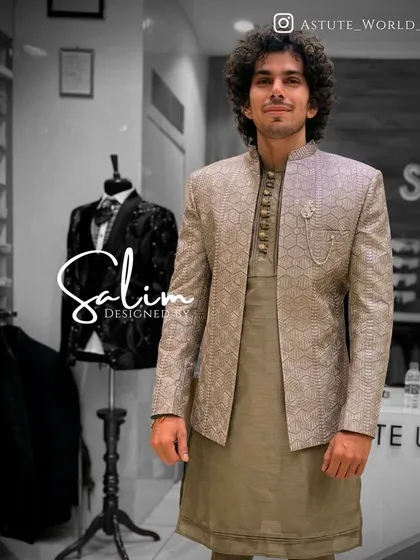 A client wearing a textured grey Indo-Western jacket over a matching kurta. The subtle geometric pattern and brooch detail add a touch of modern sophistication.