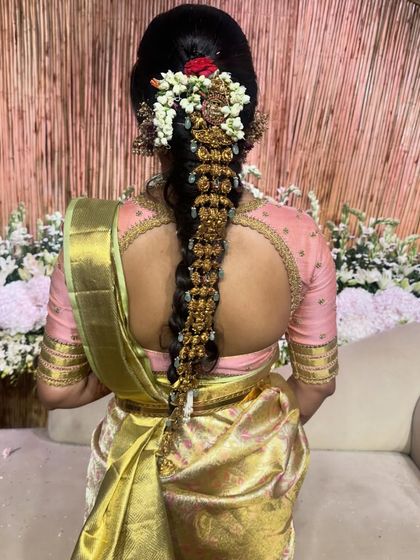 A back view of Akanksha's engagement blouse, showing the intricate cut-work and her beautiful bridal hairstyle.