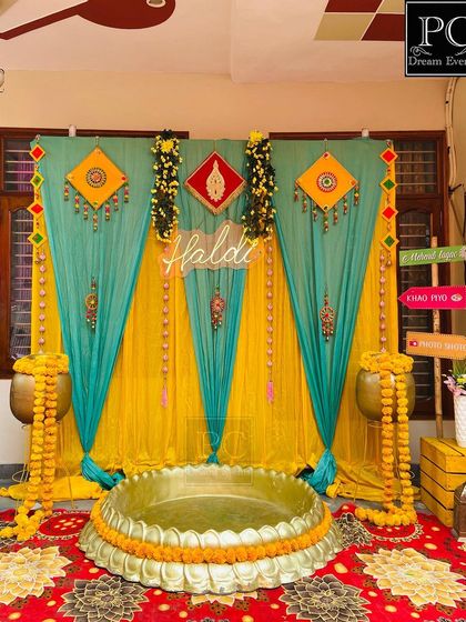 A slightly different angle of the teal and yellow Haldi decor, showing the placement of the quirky direction signs and the overall composition of the space.