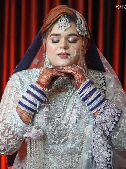 A serene portrait of the bride with her eyes closed, as if making a wish. This shot highlights her makeup and the peaceful moments before the ceremony begins.