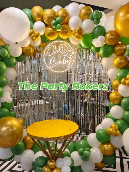 A closer view of the green and gold baby shower balloon ring, showing the mix of matte and chrome balloons.