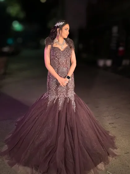 A full-length shot of the brown fish-cut gown, showcasing its dramatic trail.