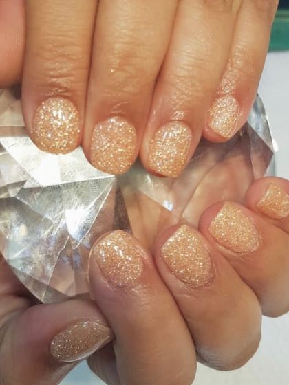 Dip powder works wonders even on the shortest nails. This glittery gold set shows how dip powder can create a beautiful, strong manicure, helping your natural nails grow out healthier.