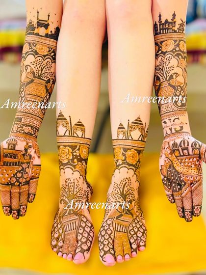 A full view of a destination-themed bridal mehndi, with cityscapes on the arms and matching architectural motifs on the feet.