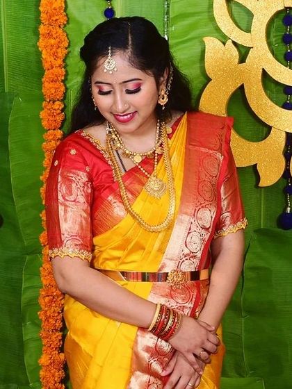 This beautiful new mother was all smiles for her daughter's naming ceremony. I gave her a classic look with dramatic winged eyeliner and a bright red lip to match her stunning yellow and red Kanjivaram saree.