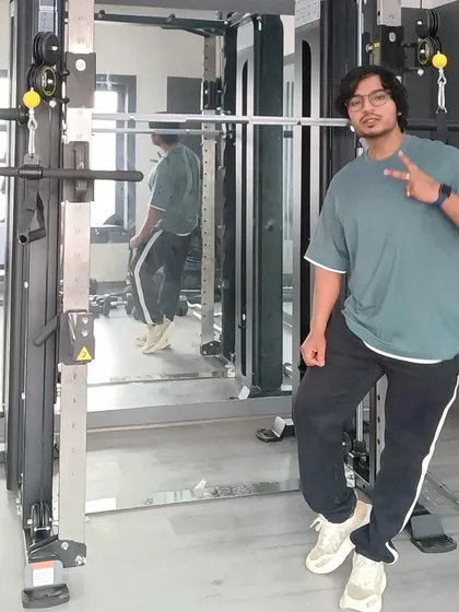 Posing next to the Smith machine. This versatile piece of equipment is great for safely performing squats, presses, and more.