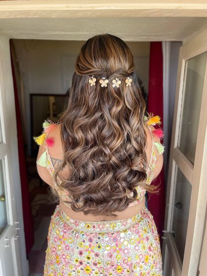 The back view of the half updo with floral clips. The highlights in her hair are beautifully defined by the waves.