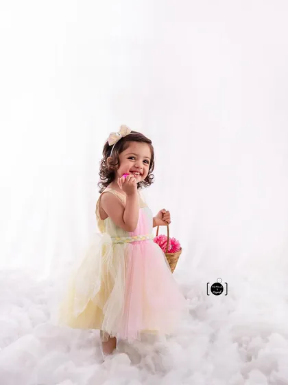 A playful, candid shot of our little flower girl, sharing a secret with her basket of flowers.