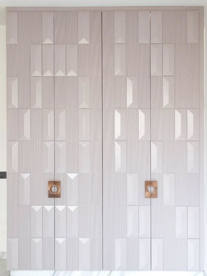A frontal view of the geometric patterned wardrobe, highlighting the precision of the CNC work and the custom copper-finished hardware that completes the look.