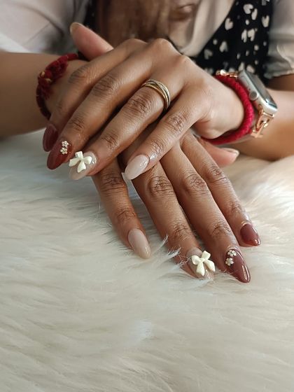 A lovely combination of neutral and brown polishes with delicate 3D white bows.