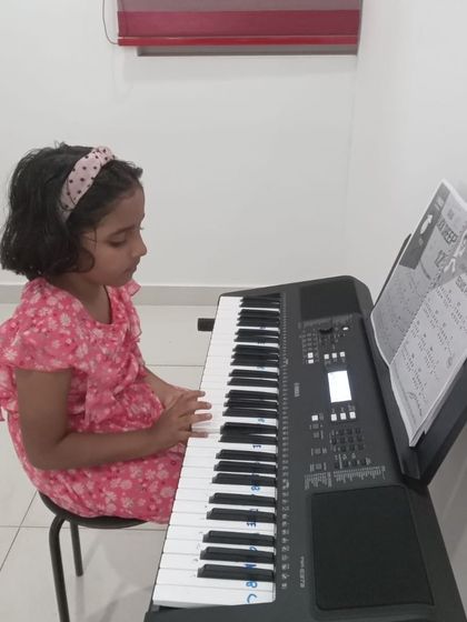 A young girl focused on her keyboard practice.