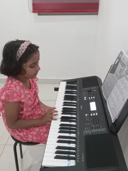 A young girl focused on her keyboard practice.