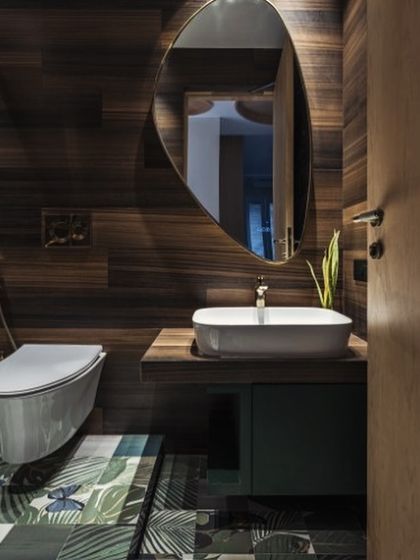 Step into paradise with this tropical bathroom oasis. The floor, with its pattern of lush palm leaves, and the warm wood-paneled walls create a whimsical haven where worries melt away.