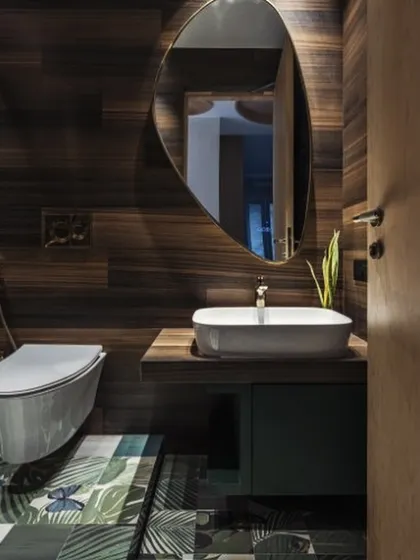 Step into paradise with this tropical bathroom oasis. The floor, with its pattern of lush palm leaves, and the warm wood-paneled walls create a whimsical haven where worries melt away.