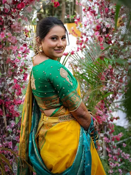 A back view of the bride, showing her elegant hairstyle and the beautiful design of her blouse.