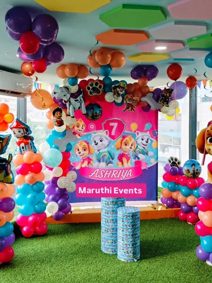 A Paw Patrol party for a 7th birthday, with a focus on the girl pups. The pink and purple decor includes a character backdrop and balloon columns.